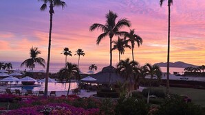 A resort with a pool, palm trees, and a sunset view. - Beachfront 2BR Condo | Casa Del Mar Dorado 101 (San Jose del Cabo)