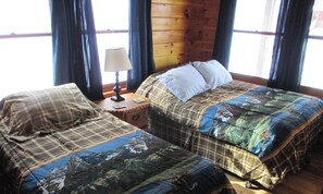 A room with two beds, a nightstand, a lamp, and a window with curtains. - 'Beautiful 7 BR 5 Bath Log Home with a game room, Hot Tub, and Starlink internet (Franklin)