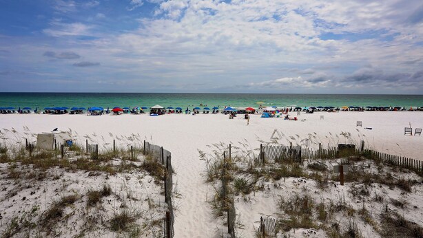A beach with umbrellas and beach chairs, a wooden fence, and a clear sky. - Caribbean Dunes 2BR/2BA with The Best Gulf View (Destin)