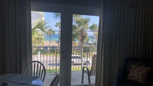 A room with a sliding glass door leading to a balcony with a view of the ocean and parked cars. - Caribbean Dunes 2BR/2BA with The Best Gulf View (Destin)