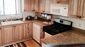 A compact kitchen with wooden cabinets, a microwave, a toaster, a blender, and a stove. - ABSOLUTE SKI-IN/OUT IN TOWN! GREAT VIEWS! HOT TUB! PRIVATE GARAGE! 2 BED + LOFT! (Telluride)