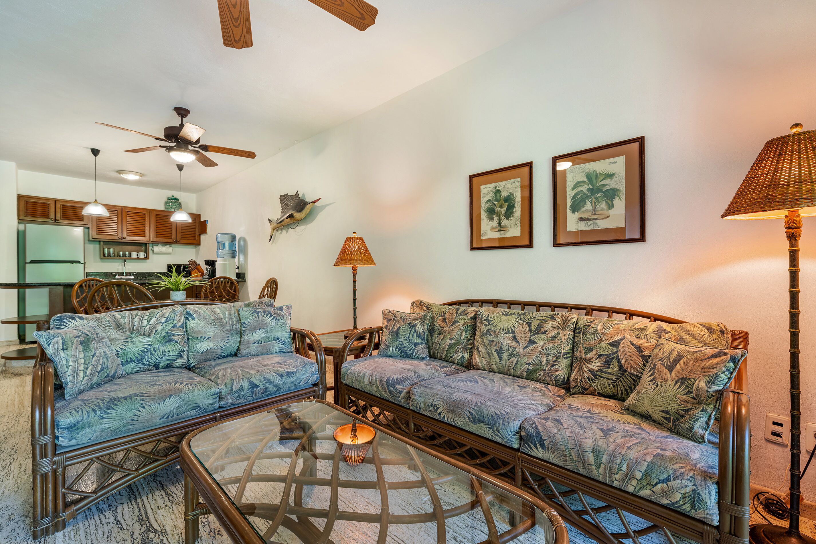 A living room with a sofa, coffee table, and a ceiling fan.