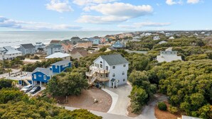 A coastal residential area with houses, a driveway, and a view of the ocean. - 3rd Row Oceanview,Private pool,hot tub,pet friendly,very short walk to beach (Emerald Isle)