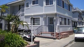 A two-story house with a porch, a garage, and a small driveway. - Spacious 5 bedroom home, 1 block from beach (Avalon)
