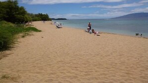 A sandy beach with people and umbrellas. - ❤️Luxury 2 BD Condo at Honua Kai Resort on the Beach ❤️ (Kaanapali)