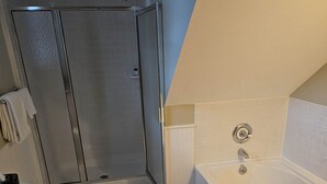 Moderni kylpyhuone, jossa on suihku, wc ja kylpyamme.