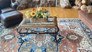A log cabin interior with a stone fireplace, leather furniture, and a decorative chandelier. - Exclusive Family Luxury Mountaintop Lodge on 43 acres (Granby)