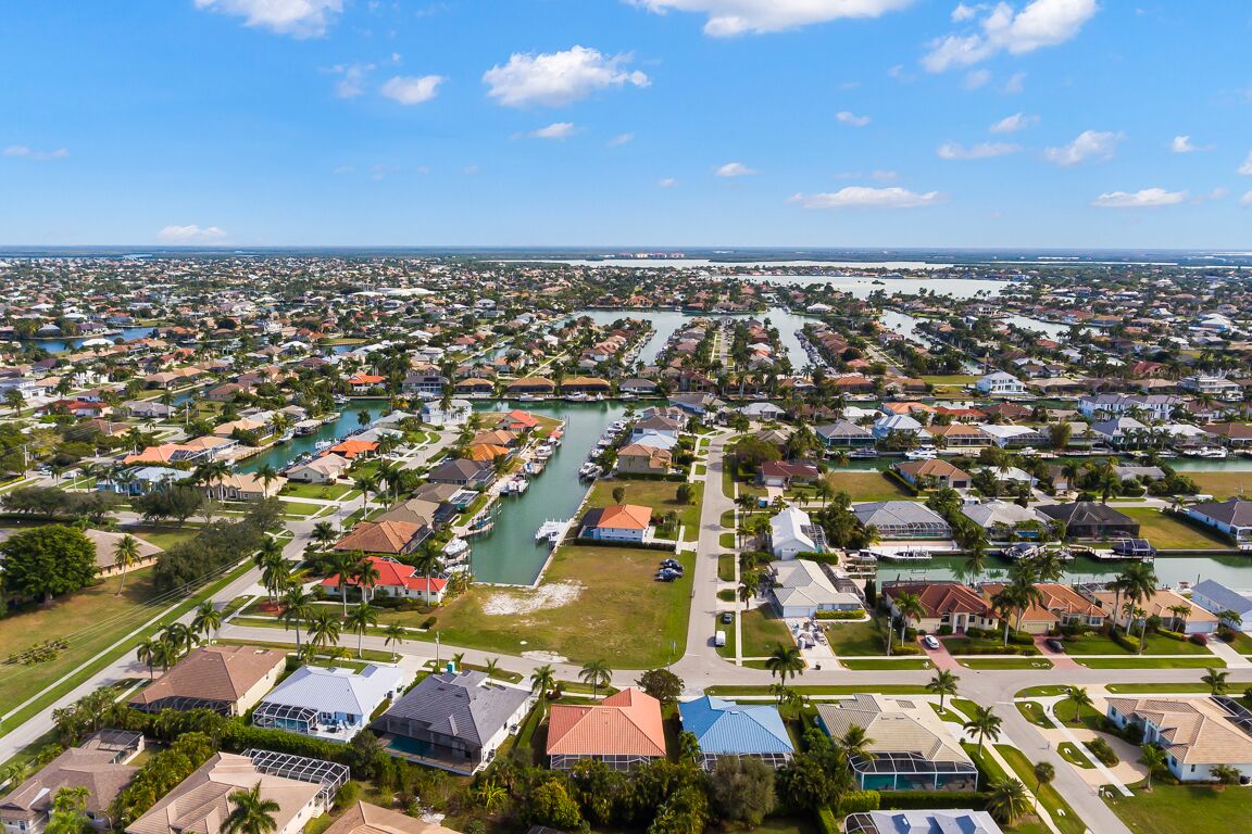 A residential area with houses, a marina, and a large body of water.