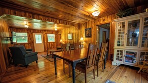 Un intérieur en bois comprenant une table à manger, des chaises et un buffet aux portes vitrées.