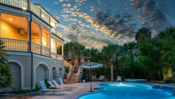 A two-story building with a swimming pool, outdoor seating, and a staircase leading to the upper level. - Villa Del Mare PRIVATE POOL/HOT TUB, OCEAN VIEWS, ELEV! (Isle Of Palms)