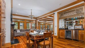 A spacious living area with a wooden dining table, comfortable seating, and a kitchen with modern appliances. - Villa Del Mare PRIVATE POOL/HOT TUB, OCEAN VIEWS, ELEV! (Isle Of Palms)