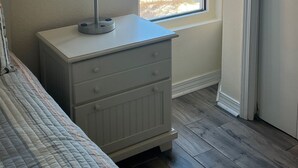 A bedroom with a bed, a bedside table with a lamp, a window with a view of the beach and ocean. - Save 10% Last min & Week! Gulf Front, Panoramic Views, Beach Supplies, Pool! (Orange Beach)