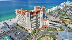 A high-rise hotel with multiple floors, a parking garage, and a beach view. - Less Crowds More Paradise! Enjoy Sea View at the Shores of Panama  2 br, 2 bath (Panama City Beach)