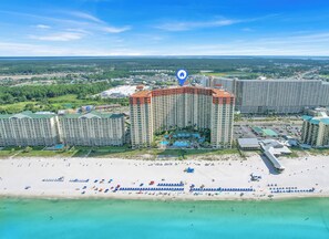 A large hotel complex with multiple high-rise buildings, a beachfront, and a clear view of the surrounding landscape.