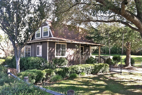 The 2-story cottage is nestled in your very own park-like setting