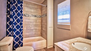 Bañera con ducha, toallas, jabón, shampoo