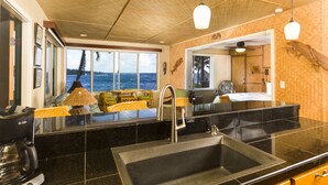 Una cocina con una isla grande, un fregadero y vistas al océano a través de amplios ventanales.