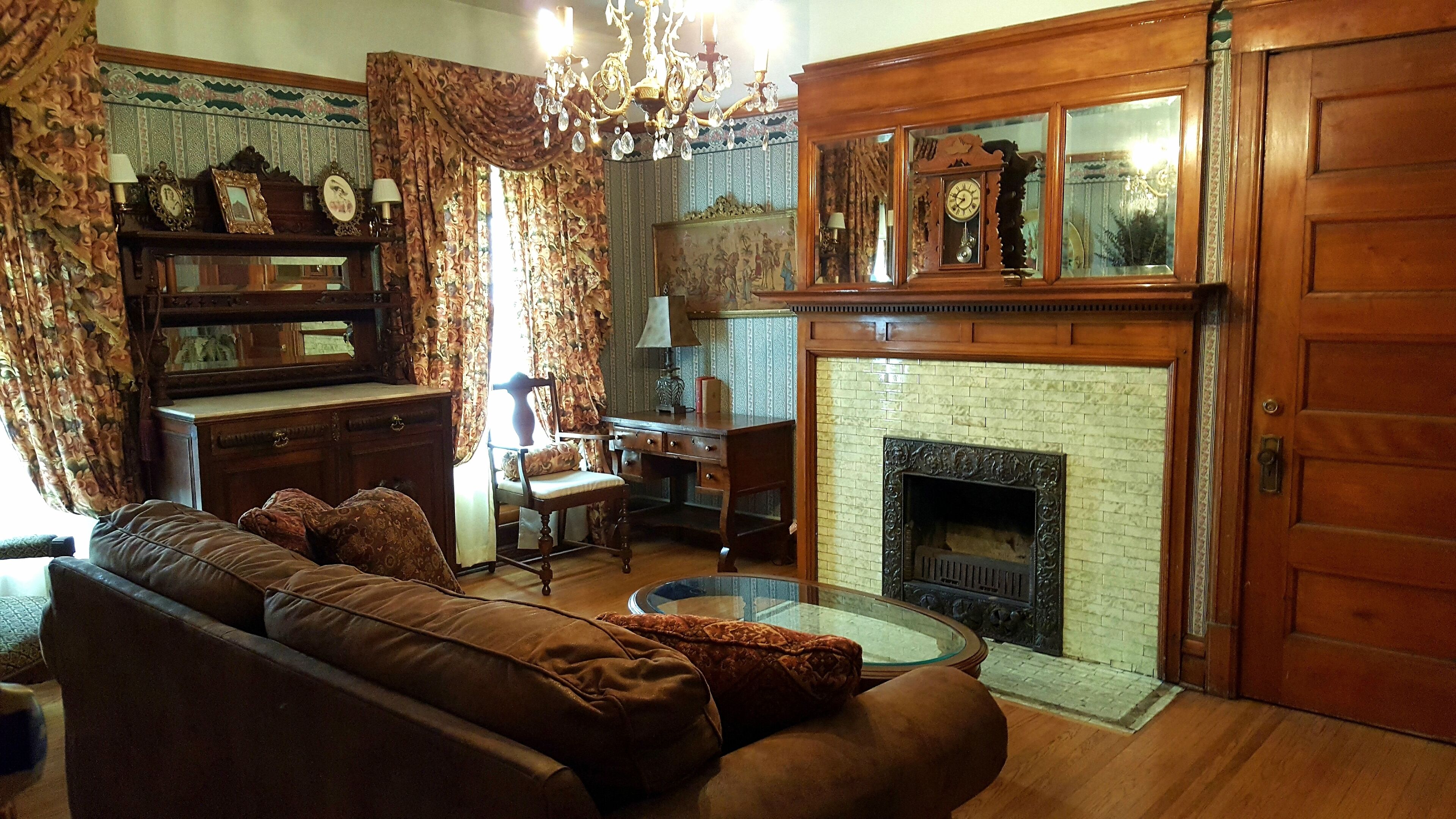 Un salon traditionnel avec une cheminée, des meubles en bois et un lustre.