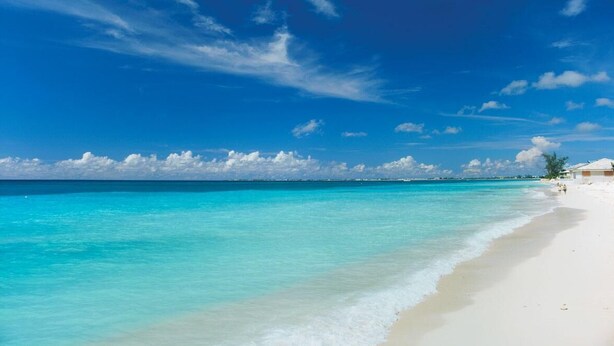 Ein Strand mit klarem türkisblauem Wasser und einem sandigen Ufer.