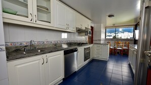 A kitchen with white cabinets, a granite countertop, and a view of a cityscape through a window. - Exc PH, Best Loc, Near Carolina, Huge Balcony, AMZ Views, WiFi, APU, 💲Deals! (Quito Canton)