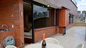 An outdoor patio with a round table, a bottle of wine, and a hose connected to a water dispenser. - Exc PH, Best Loc, Near Carolina, Huge Balcony, AMZ Views, WiFi, APU, 💲Deals! (Quito Canton)