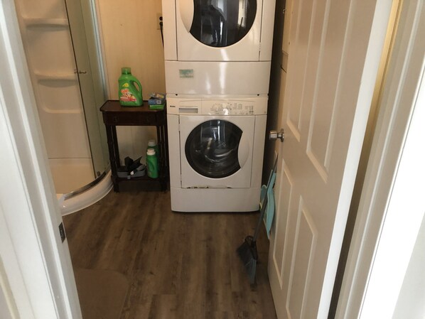 Una sala de bugaderia amb piles de rentadores i assecadores, una escombra i productes de neteja.
