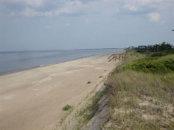 A sandy beach with a wooden walkway leading to a structure. - Summer getaway.  Right on the water.  3 bedrooms pets permitted. (Milton)
