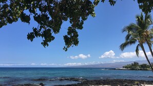 A beach with clear blue water, a sandy shore, and a few palm trees. - Enjoy a Hawaiian vacation in Paradise Stay @ The World Famous Mauna Lani Resort (Puako)
