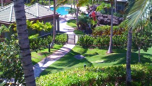 A resort with a swimming pool, palm trees, and a pathway leading to a building. - Enjoy a Hawaiian vacation in Paradise Stay @ The World Famous Mauna Lani Resort (Puako)