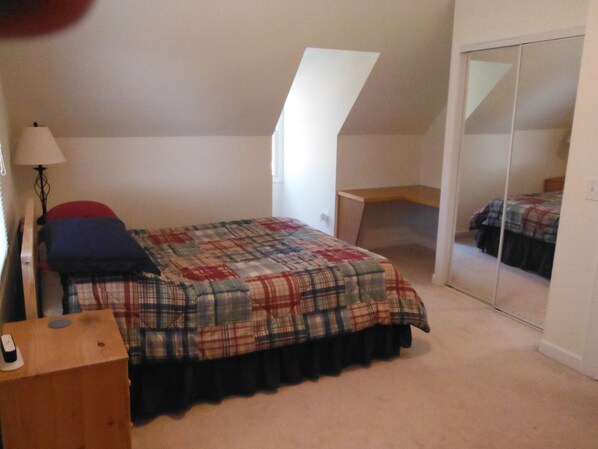 A bedroom with a bed, a desk, a lamp, and a mirror. - Pet Friendly Rental Cabin In The Heart Of Wine Country (Mount Airy)