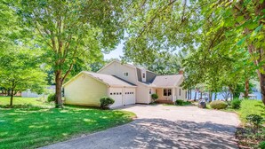 A two-story house with a garage, a covered porch, and a driveway leading to the front door. - BREATHTAKING VIEWS AT NORMANDY BREEZE! (Denver)