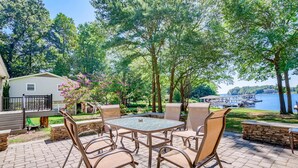 An outdoor patio with a round table and chairs, surrounded by stone walls and trees. - BREATHTAKING VIEWS AT NORMANDY BREEZE! (Denver)