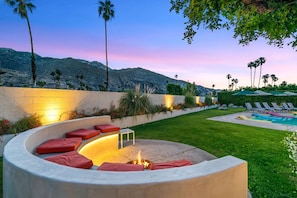 A landscaped outdoor area with a curved seating area, a pool, and palm trees. - NEW! Private Wellness Resort! Pool, Spa, Cold Plunge & Cabanas Indian Canyons PS (Palm Springs)