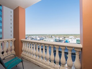 Enjoy the view from this balcony with a balustrade and a comfortable chair.