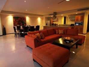 Relax in this stylish living room with a plush sofa, dining area, and modern kitchen.