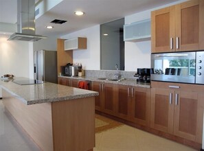 Enjoy cooking in this kitchen with a sleek island, microwave, and stainless steel range hood.