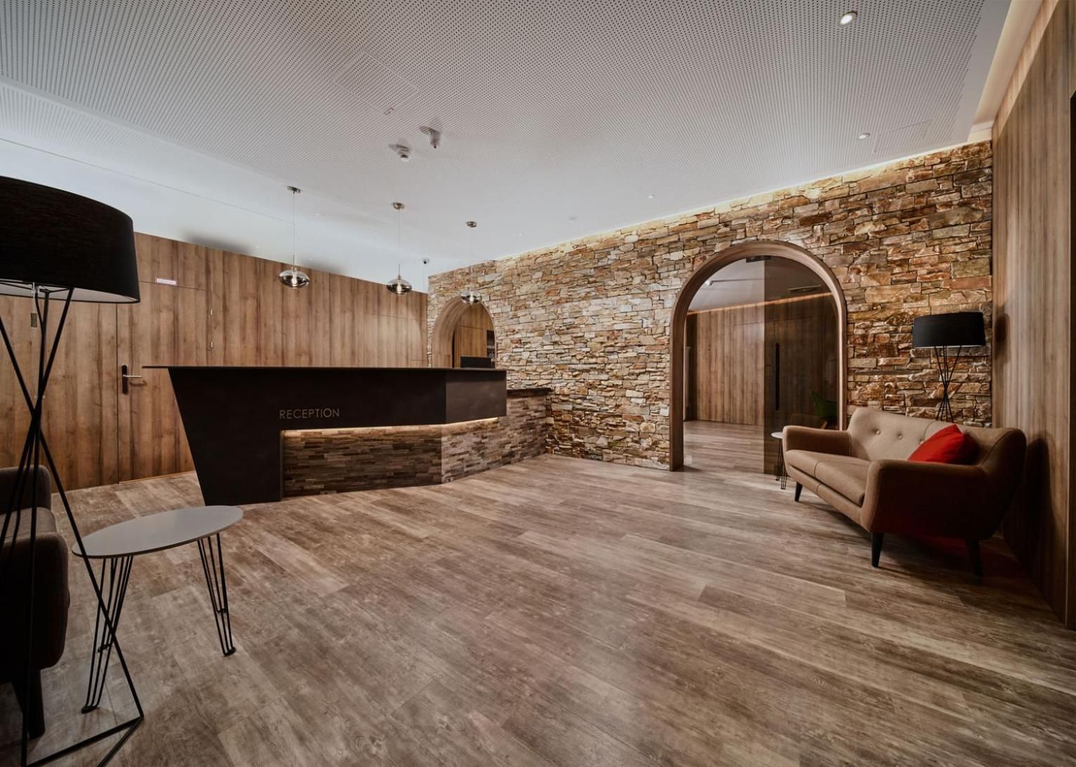 Ein Empfangsbereich mit einer Rezeption, einer Couch und einer Lampe.