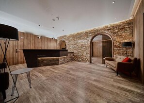 Un espace d’accueil comprenant un comptoir de réception, un canapé et une lampe.