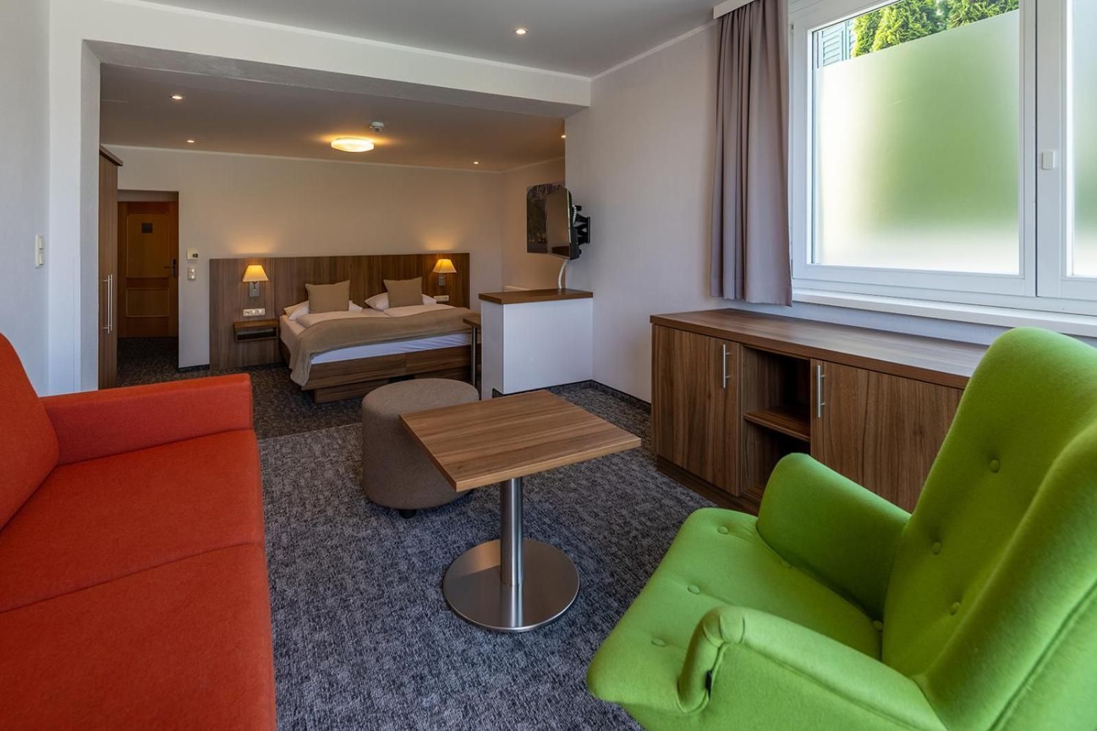 Ein Hotelzimmer mit einem Bett, einem Schreibtisch, einer Couch und einem Sessel.