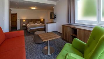 Ein Hotelzimmer mit einem Bett, einem Schreibtisch, einer Couch und einem Sessel.