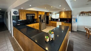 A modern kitchen with wooden cabinets, stainless steel appliances, and a central island. - Luxury Riverfront Home w/ Pool • Private Boat Dock • Minutes to Laughlin (Bullhead City)