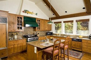 Enjoy cooking in this well-equipped kitchen with a central island, stove, microwave, and dishwasher.