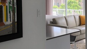 A modern living room with a sofa and a dining table. - Convenient Location in Condado! (Santurce)