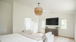 Une chambre moderne avec un grand lit, une télévision et une fenêtre.