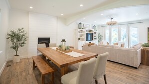 Un vaste espace de vie comprenant une table à manger en bois, des sièges confortables et une cheminée.
