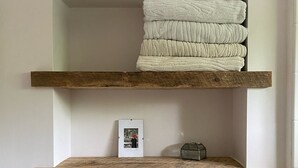 A bathroom with wooden shelves holding towels and toiletries. - PRICE REDUCED Family Friendly, 3Bd Centrally Located Home with Fenced in Yard (Montauk)