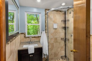 Une salle de bain moderne avec une douche, un lavabo et une fenêtre.