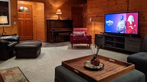 Uma sala de estar acolhedora com decoração em madeira, televisão, piano e assentos confortáveis.