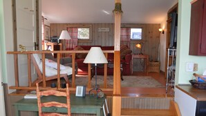 A wooden interior with a sofa, a table, and a chair. - Watch the sun rise without getting out of bed! (South Thomaston)