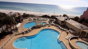 A pool area with multiple swimming pools, lounge chairs, and a view of the beach. - 9th Floor Beach Front Condo Tides @ Topsl (Destin)